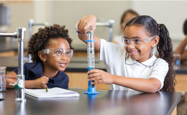 Two girls look at a tube while performing science
